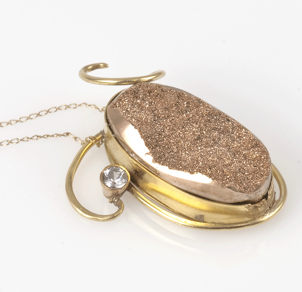 Rose Gold Druzy Filigree set in 14 Karat with a white Sapphire accent.